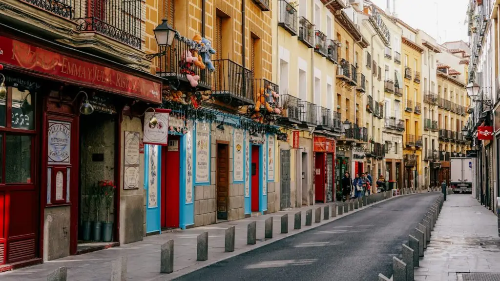 A Madrid street lined with tall apartment buildings, where the district you live in shapes the schools you can apply to