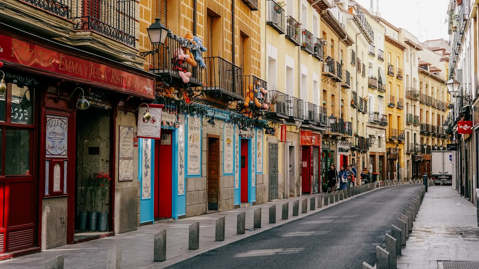 A Madrid street lined with tall apartment buildings, where the district you live in shapes the schools you can apply to