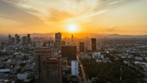 The Mexico City skyline at sunset, seen from above with mountains on the horizon