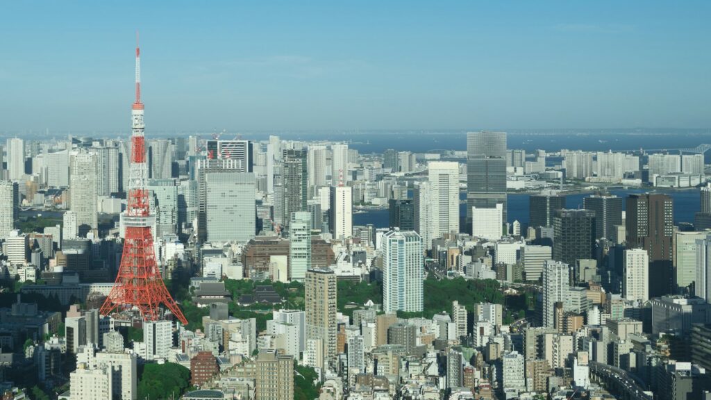 The Tokyo skyline and Tokyo Tower under a clear blue sky, with the bay beyond