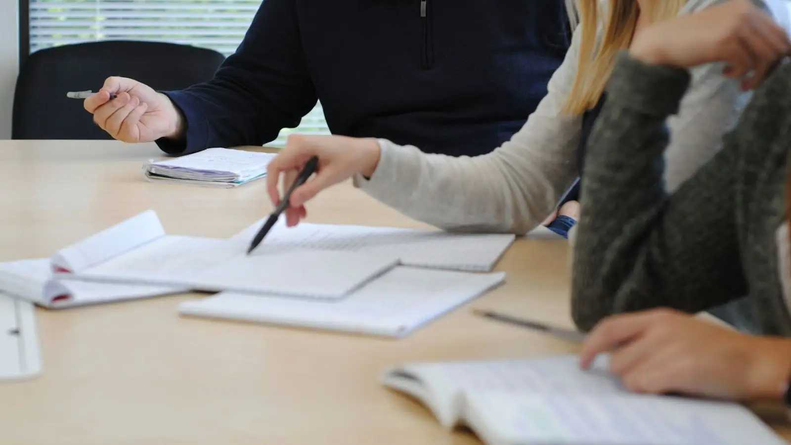 Colleagues planning together around a table covered with notes and documents