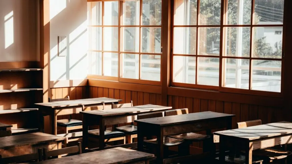 An empty classroom with wooden desks and afternoon light