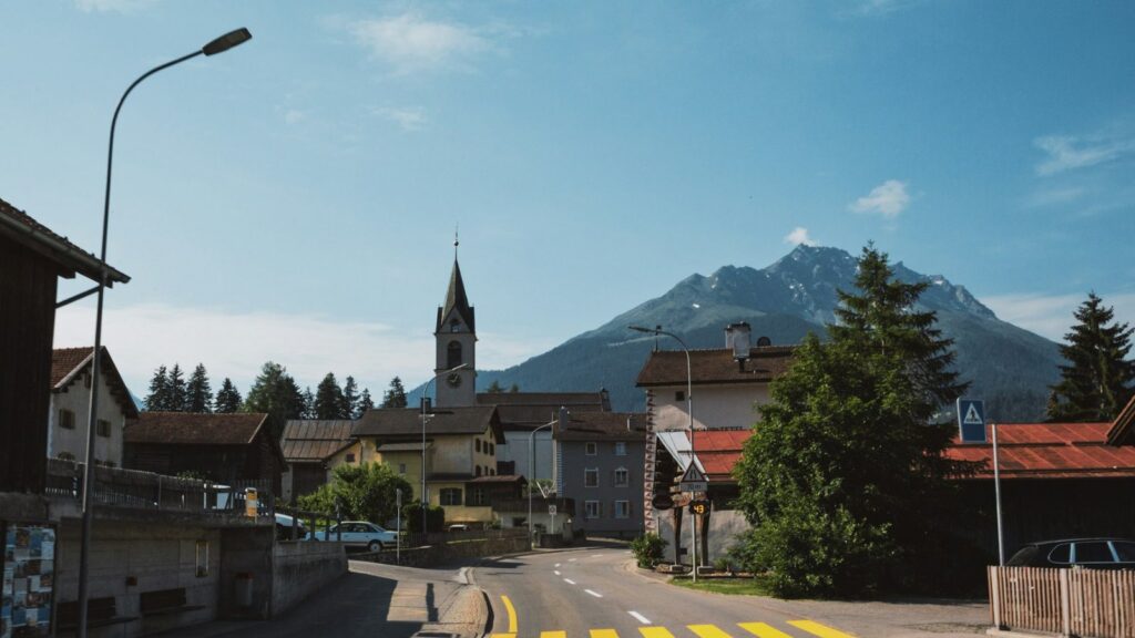 A small village with a church below snow-capped mountains
