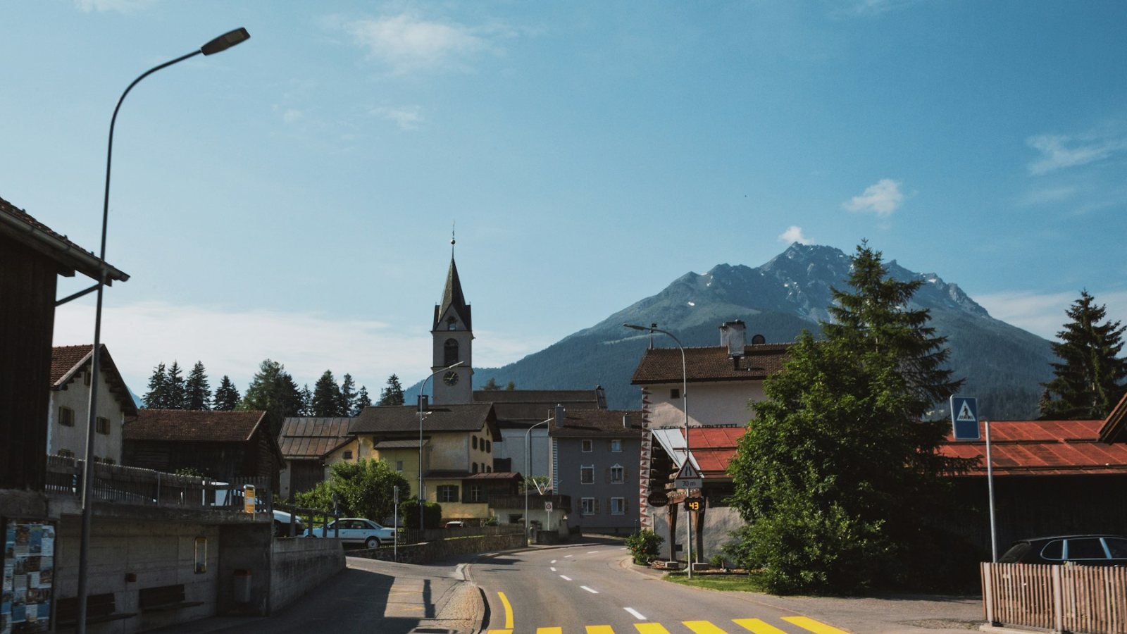 A small village with a church below snow-capped mountains