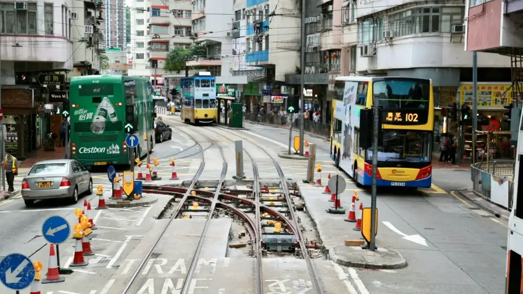 A Hong Kong street with tram tracks, a double-decker tram and a bus