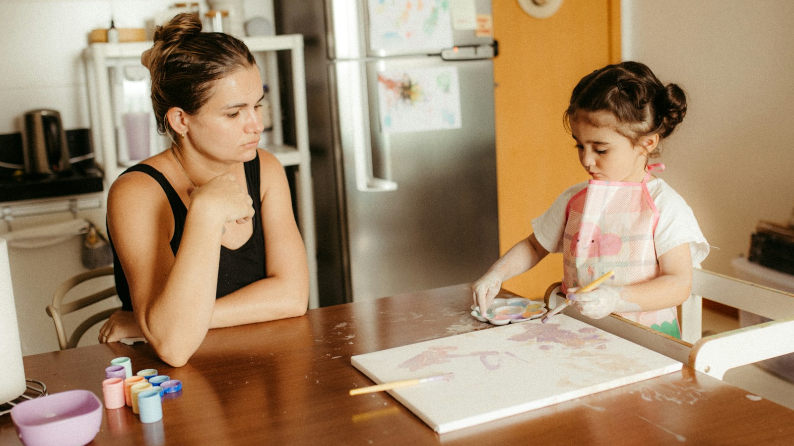 A mother and daughter sit together at the kitchen table, the setting where many families start planning for a school application year.