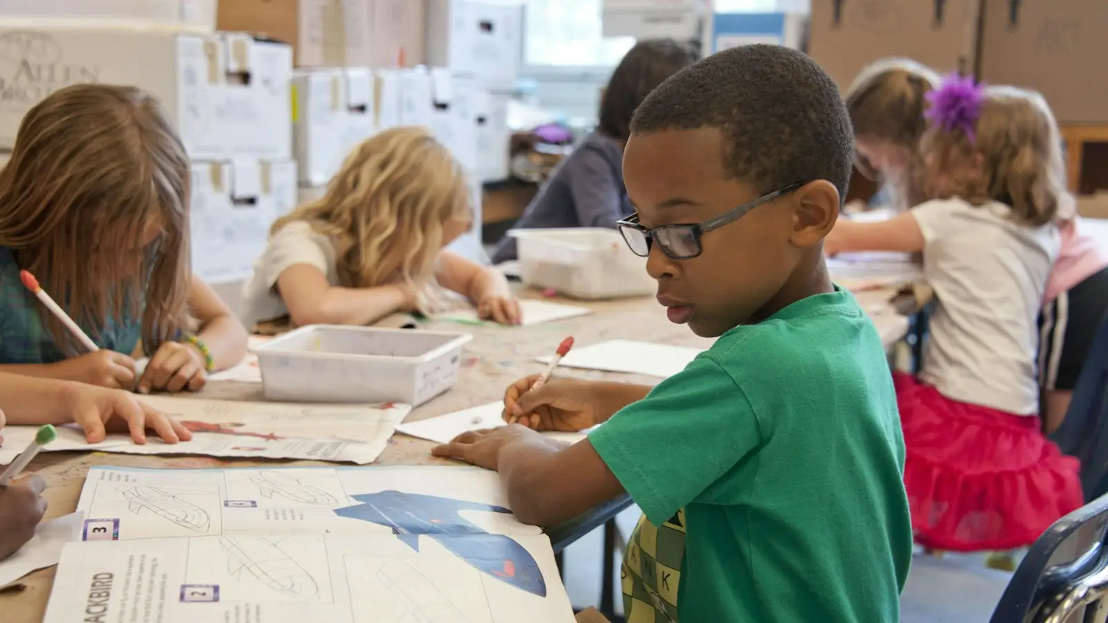 Young children writing at their desks in a US primary school classroom