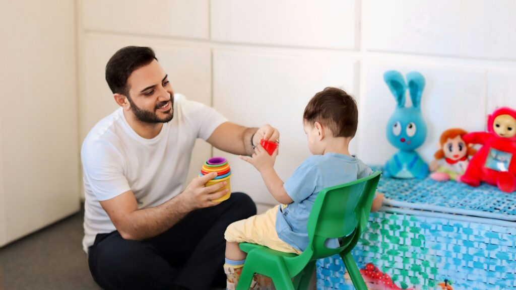A therapist plays with a young child during a one-to-one session.